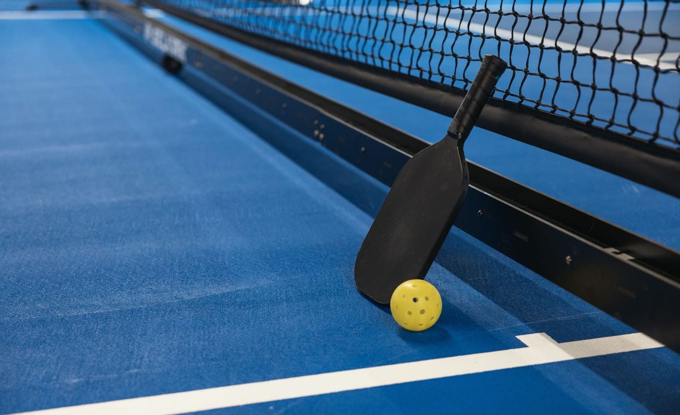 Pickleball paddle and ball on a court